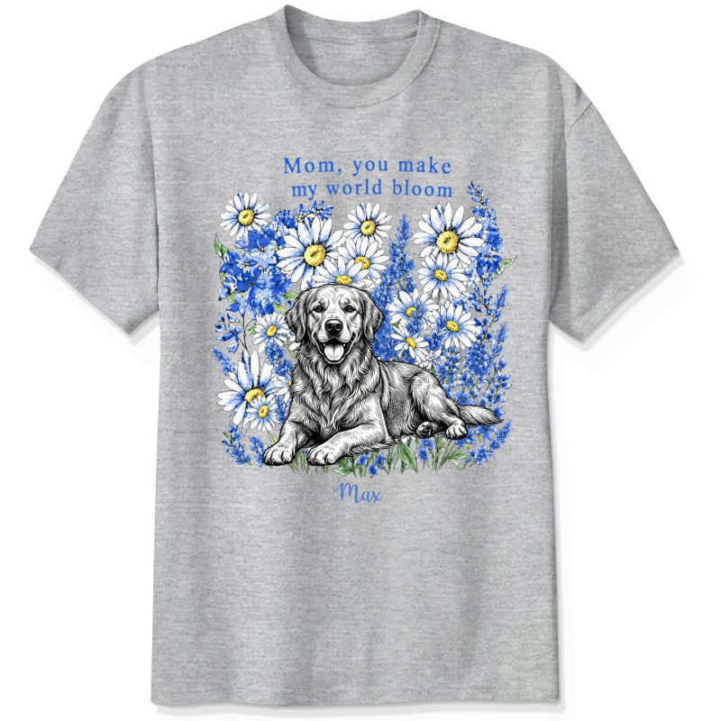 An ash gray custom dogs t-shirt featuring a graphic print of a golden retriever dog surrounded by blue flowers, with the text 'Mom, you make my world bloom' and dog's name written below.