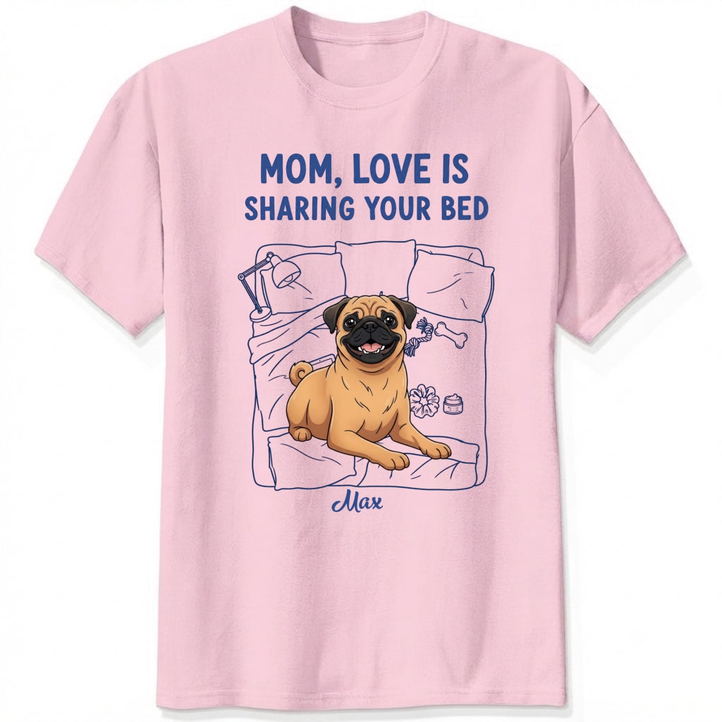 A pink short-sleeve t-shirt with a graphic of a pug dog on a bed and the text 'MOM, LOVE IS SHARING YOUR BED' in blue, with Dog's name written below. Custom with many dog breeds to choose from