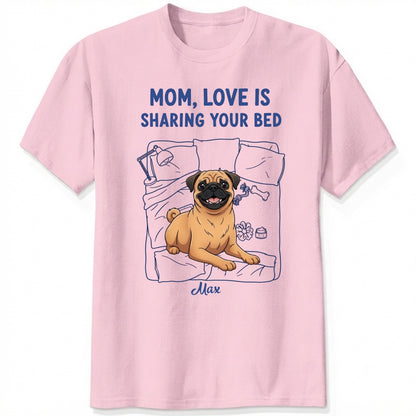 A pink short-sleeve t-shirt with a graphic of a pug dog on a bed and the text 'MOM, LOVE IS SHARING YOUR BED' in blue, with Dog's name written below. Custom with many dog breeds to choose from