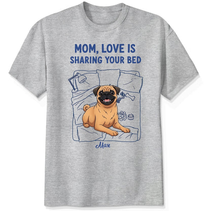 An ash grey short-sleeve t-shirt with a graphic of a pug dog on a bed and the text 'MOM, LOVE IS SHARING YOUR BED' in blue, with Dog's name written below. Custom with many dog breeds to choose from