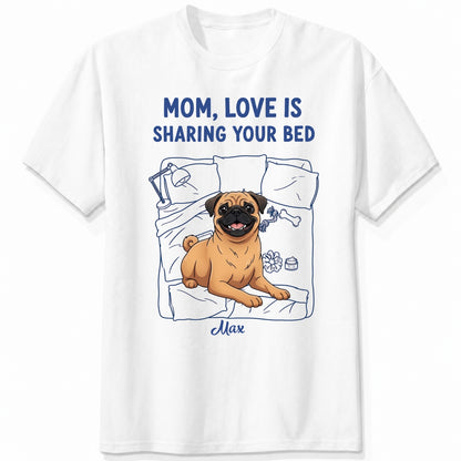 A white short-sleeve t-shirt with a graphic of a pug dog on a bed and the text 'MOM, LOVE IS SHARING YOUR BED' in blue, with Dog's name written below. Custom with many dog breeds to choose from