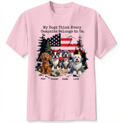 A pink short-sleeve t-shirt featuring a graphic print of dogs sitting in front of a campfire and an American flag, with the text 'My Dogs Think Every Campsite Belongs to Us.' and custom with dog's names below.