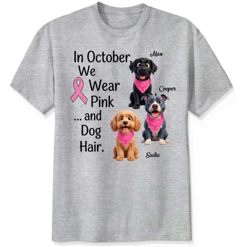 An ash grey short-sleeve crewneck t-shirt featuring a graphic print with three dogs wearing pink bandanas and the text 'In October, We Wear Pink and Dog Hair.'