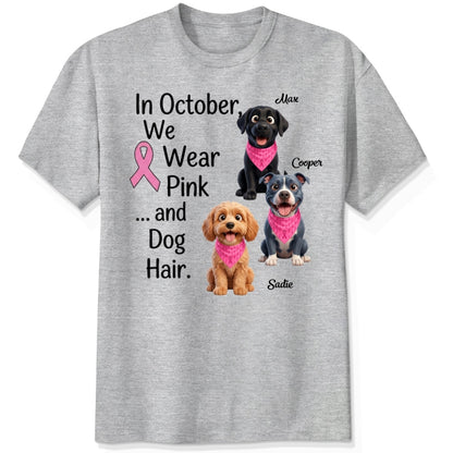 An ash grey short-sleeve crewneck t-shirt featuring a graphic print with three dogs wearing pink bandanas and the text 'In October, We Wear Pink and Dog Hair.'