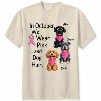 A sand short-sleeve crewneck t-shirt featuring a graphic print with three dogs wearing pink bandanas and the text 'In October, We Wear Pink and Dog Hair.'
