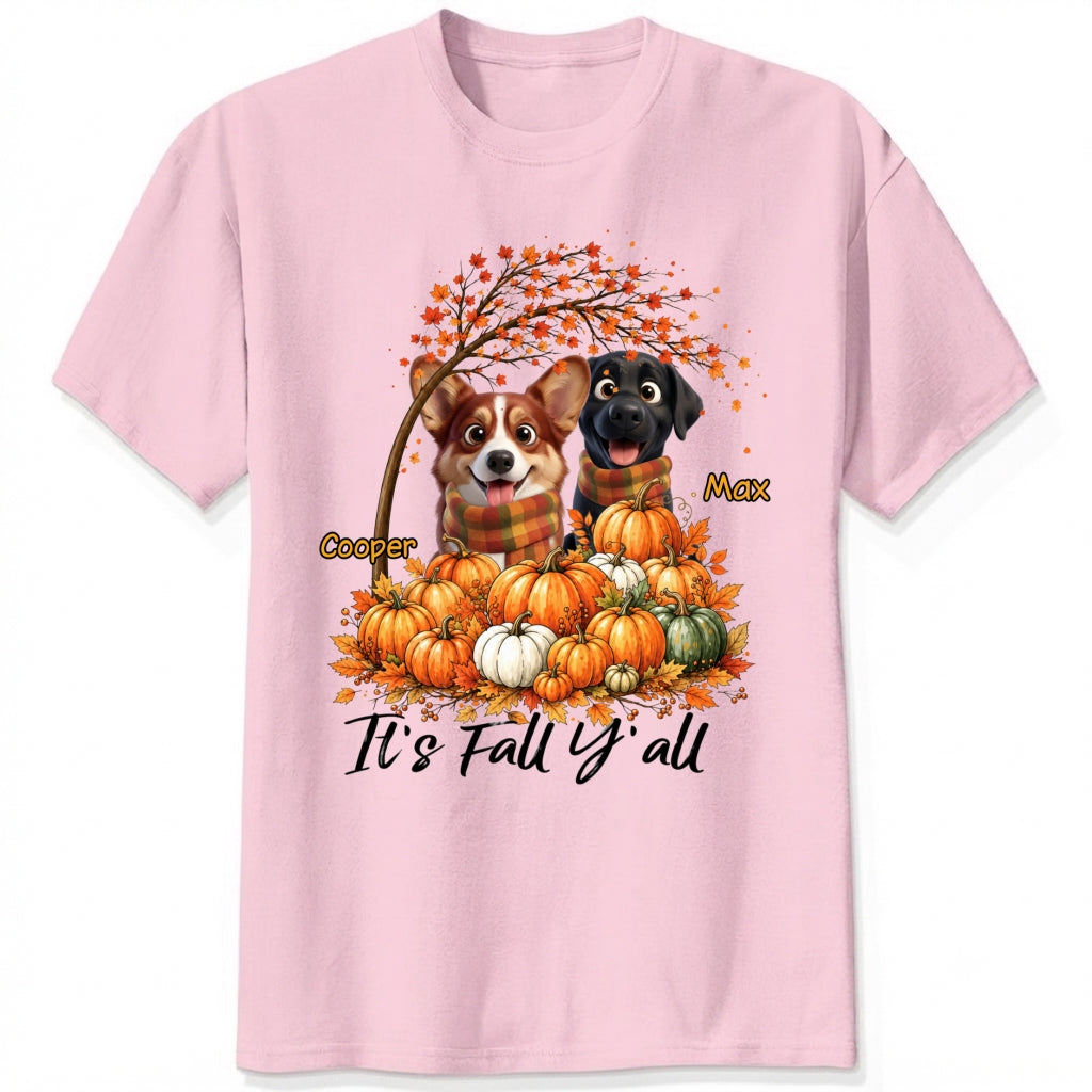 A pink short-sleeve crewneck t-shirt featuring a custom autumn graphic of custom dogs sitting on a pile of pumpkins under an orange tree, with the text 'It's Fall Y'all' and custom dog's names