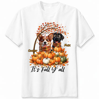 A white short-sleeve crewneck t-shirt featuring a custom autumn graphic of custom dogs sitting on a pile of pumpkins under an orange tree, with the text 'It's Fall Y'all' and custom dog's names