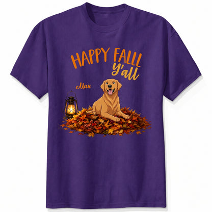 A purple short-sleeve crewneck t-shirt featuring a 'Happy Fall Y'all' graphic with custom dogs sitting on a pile of autumn leaves next to a glowing lantern.
