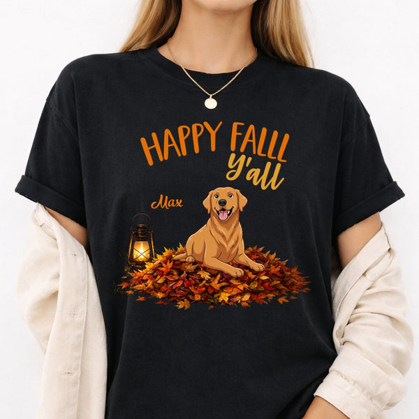 A woman wearing a black graphic t-shirt with a fall-themed design featuring a golden retriever, autumn leaves, and the text 'HAPPY FALL y'all' and the dog's name. 