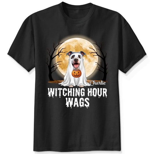 A black t-shirt featuring a Halloween graphic of dogs dressed as a ghost in front of a full moon, with the text 'Witching Hour Wags' printed below and custom with dog names.